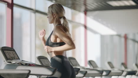 fit meisje traint cardio oefening op de loopmachine in het fitnesscentrum.