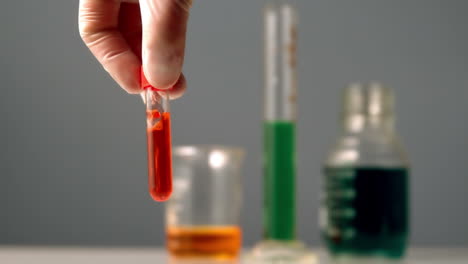científico girando el tubo de ensayo de químico rojo
