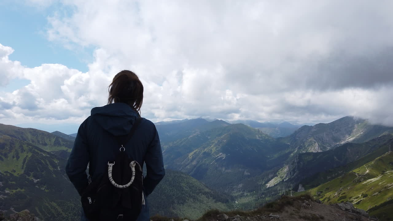 멋진 호수를 포함한 타트라 산맥의 풍경을 즐기는 소녀의 영화적 장면