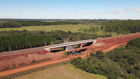 avión no tripulado se acerca a un puente en un sitio de construcción rural