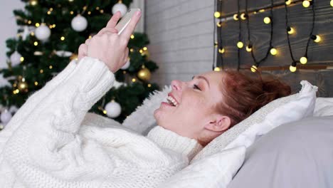 Girl-with-smart-phone-lying-on-the-bed