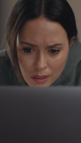 video vertical de cerca en el rostro de una mujer ansiosa sentada en el sofá trabajando desde casa usando una computadora portátil preocupada por la crisis del costo de la vida 7