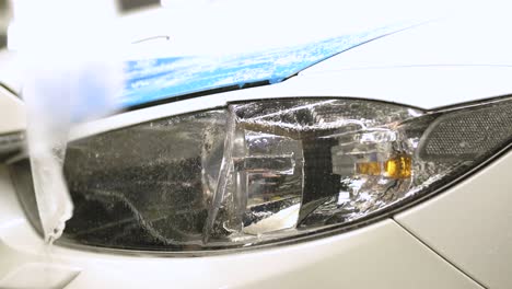 man covering car with vinyl polyurethane tape. films for the car. sticker protective film on the headlight of the car