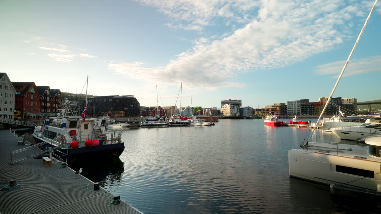Tromsø marina during the midnight sun. Yachts and boats reflect on calm Arctic waters under a bright summer sky in Norway’s far north