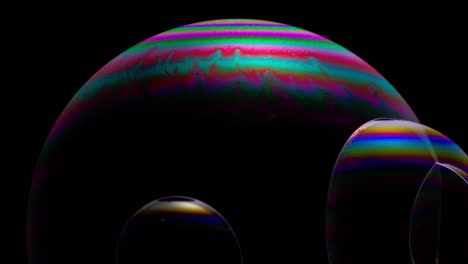 Close-up-of-soap-bubbles-on-a-dark-background,-with-a-vibrant,-multicolored,-iridescent-surface,-resembling-a-science-fiction-landscape