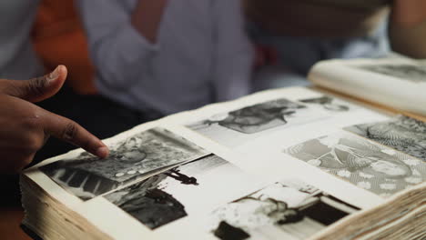 black guy looks at old photo with little girl and woman