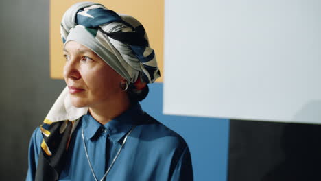 mature woman in turban posing in studio