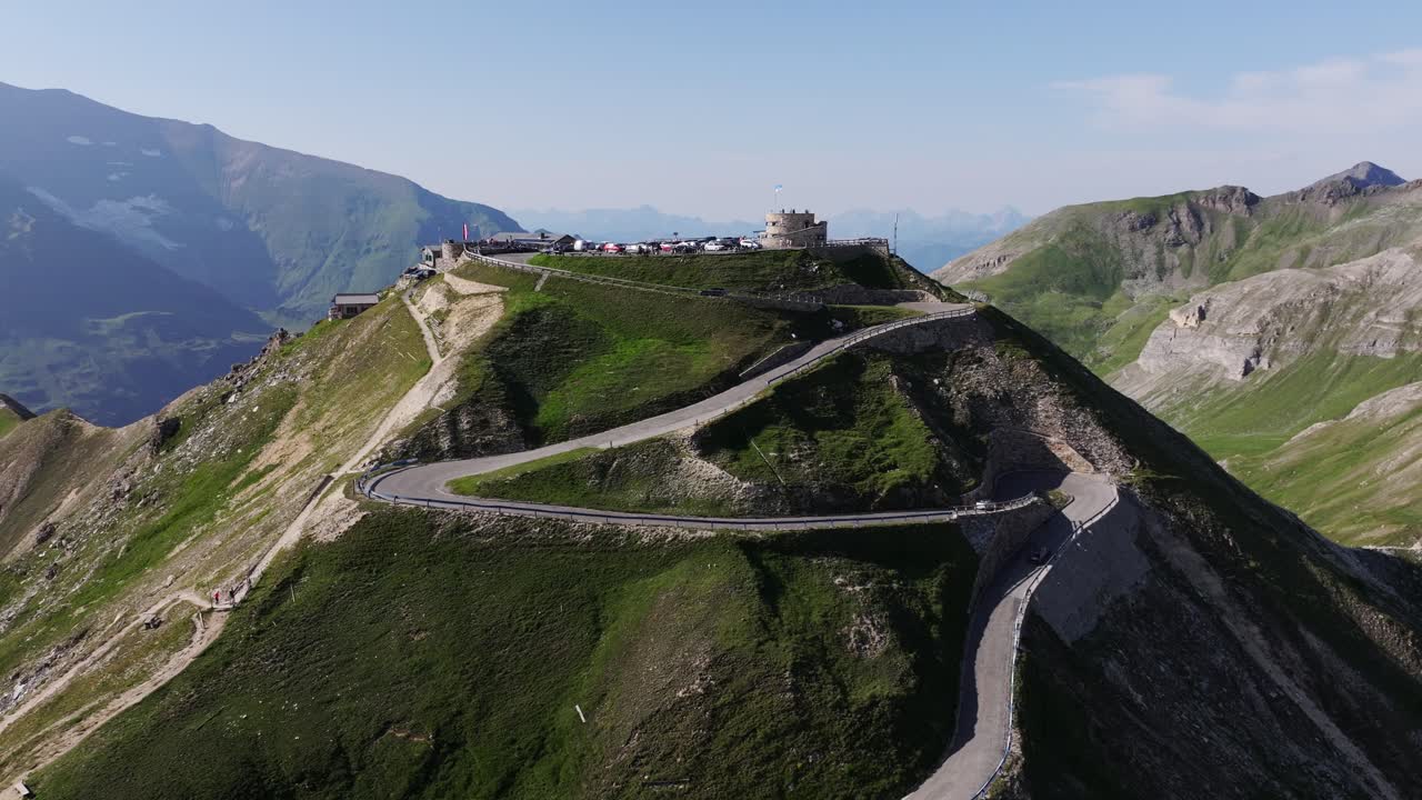 Epic serpentine road climbs scenic summit with panoramic Alpine surroundings, 4K