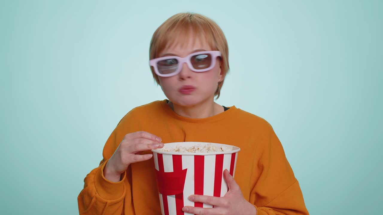 Woman in 3d glasses eating popcorn and watching interesting tv serial sport game film online movie