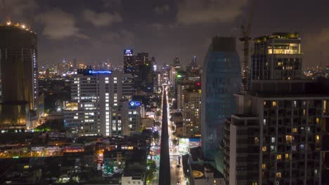 epic aerial drone night time lapse of skyline and skyscrapers of sukhumvit district and bts in bangkok, thailand