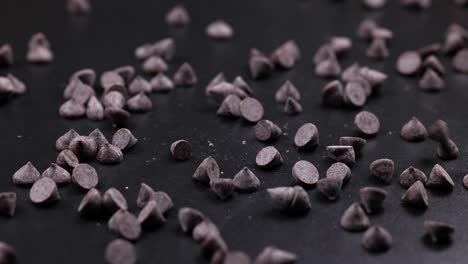 chocolate chips scatter across a dark background