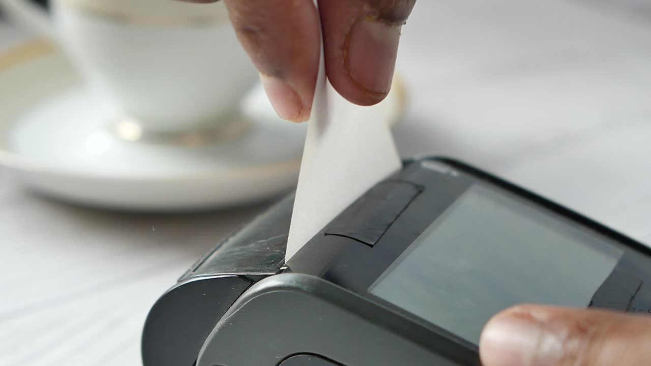 Close-up of a Person Using a Payment Terminal to Process a Transaction