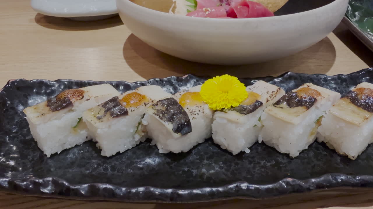 Sushi pressato tradizionale Stile Vancouver su un tavolo di ristorante, ripresa scorrevole.