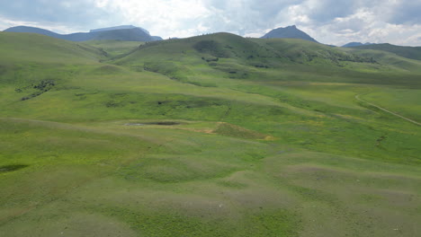 vast grassy valley with hills on a semi cloudy day and sunlight breaking through