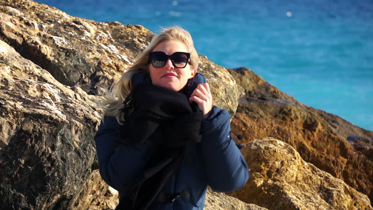 крупный план молодой женщины, наслаждающейся морским отдыхом, синее море в мягком фокусе на заднем плане slomo