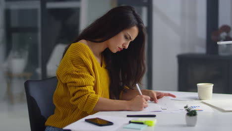 Mujer-De-Negocios-Enfocada-Tomando-Notas-Con-Lápiz-Sobre-Malos-Resultados-Financieros.