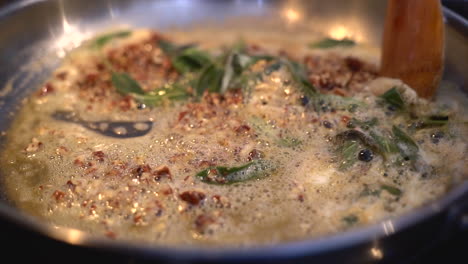 stirring a butter sage sauce in pan