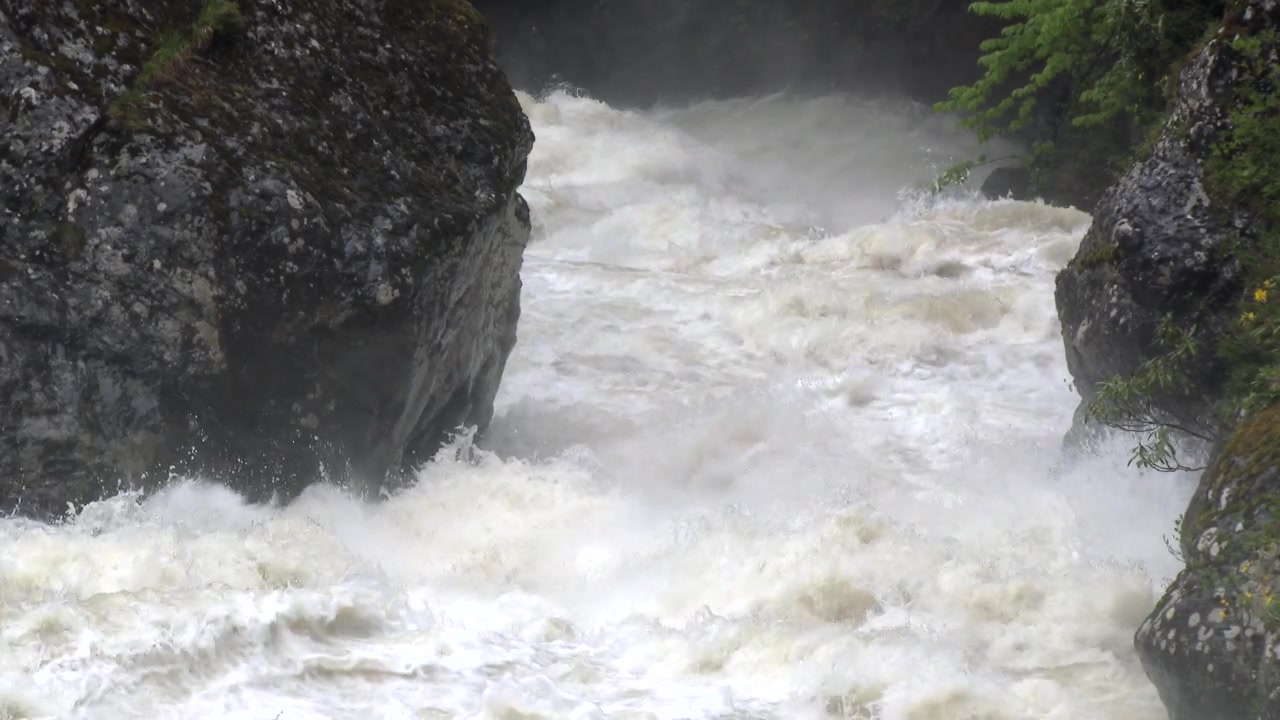 Powerful Rushing River Water Flowing Between Large Rocks