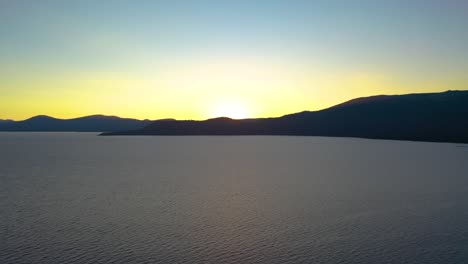 lago de piedra amarilla, wyoming hermosa puesta de sol con agua y silueta de montaña en el fondo