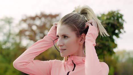 handheld view of  sporty woman listening to music by headphones