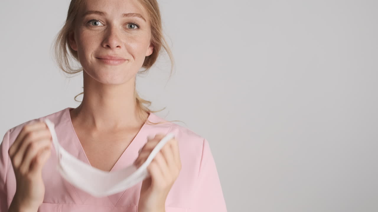 doctora caucásica quitándose la máscara médica.