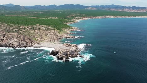 panoramic aerial overview of rocky coastline of cabo pulmo as rough ocean waves crash on beach