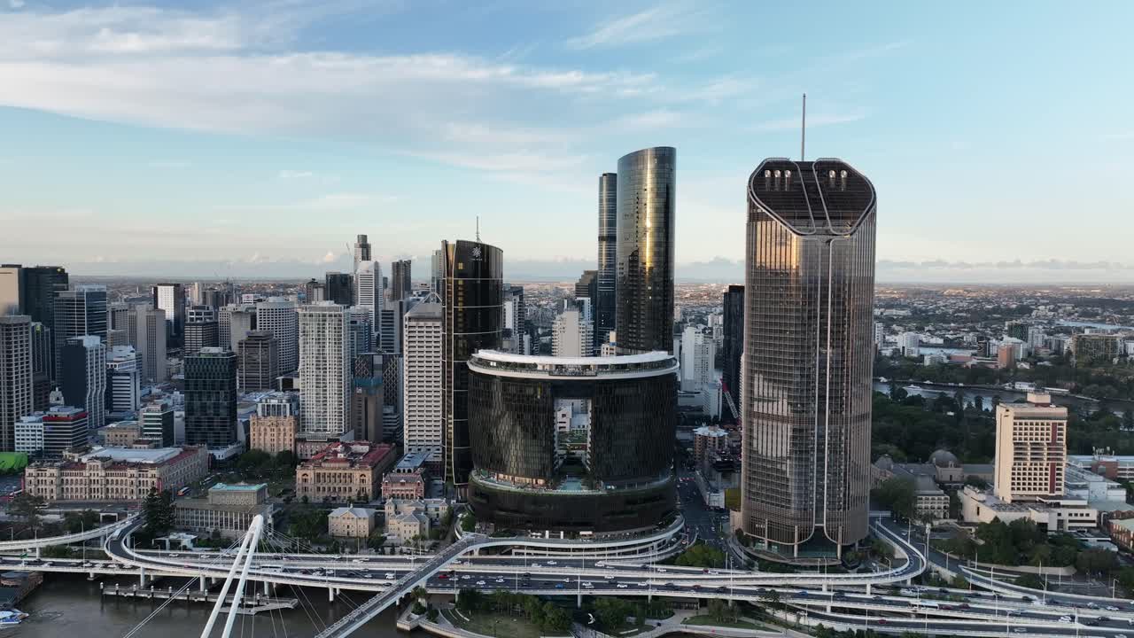 Lenta orbita di drone all'ora d'oro, rotante dallo skyline del CBD di Brisbane verso il Queens Wharf e le torri The Star Brisbane sopra il quartiere sul lungofiume, Brisbane, QLD, Australia