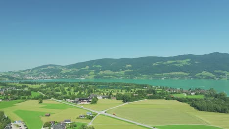 lakefront luxury: the drone captures serene mondsee lake, fringed by majestic mountains, with a glimpse of the austrian golf resort