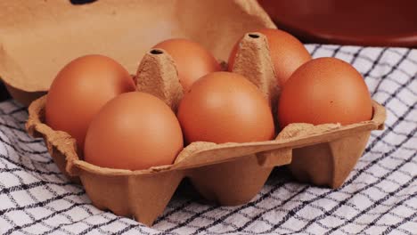 fresh chicken eggs and dried straw on black wooden table, closeup. high quality 4k footage