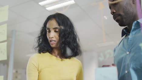 video de una mujer de negocios diversa y un hombre de negocios haciendo una lluvia de ideas en la oficina