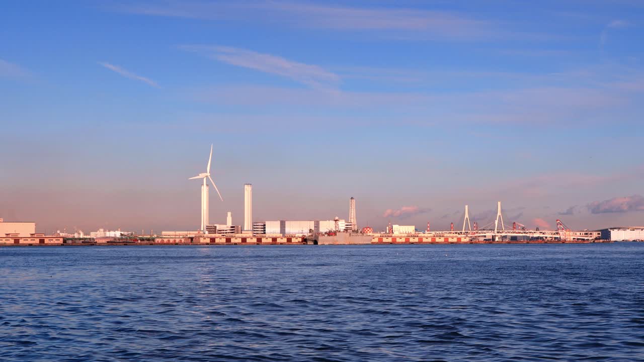 Windmill by the sea during sunset.