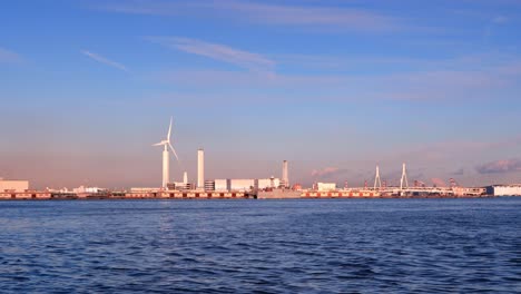 windmill by the sea during sunset.