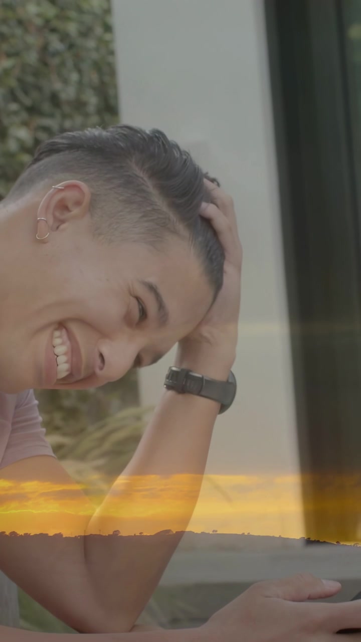 Video verticale: Uomo che tocca il telefono su un patio, legge un avviso tecnologico e sorride mentre una fascia arancione incornicia il telefono.
