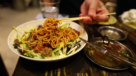 various noodle dishes being served and enjoyed