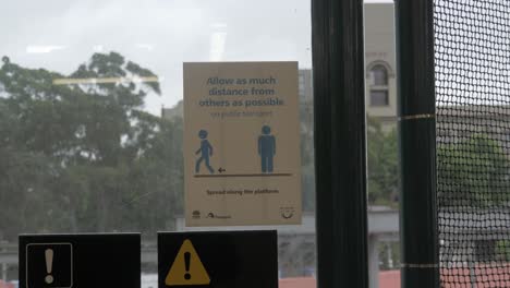 social distancing sign on glass window - redfern train station - sydney, nsw, australia