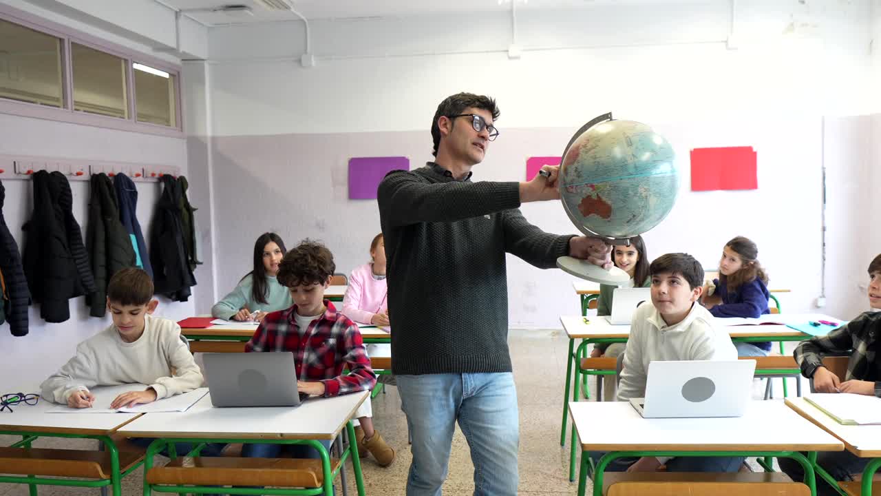 Teacher presenting a globe to students in the classroom