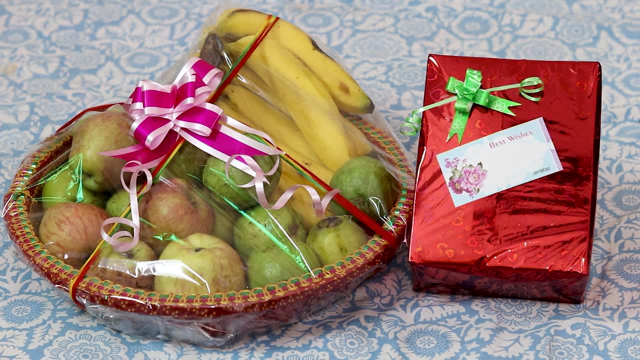 envoltura de regalo de frutas llena de diferentes frutas y paquete de regalo desde un ángulo plano