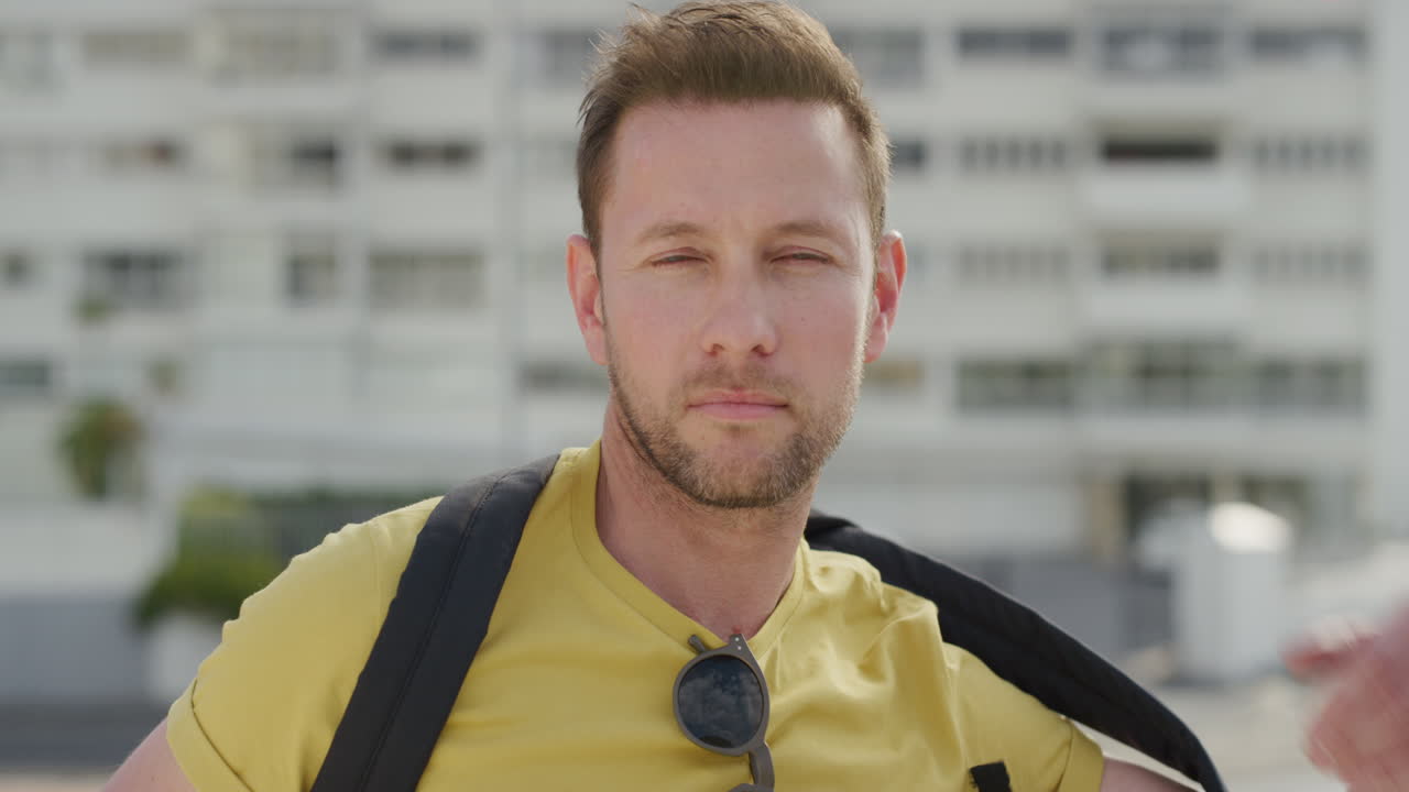 retrato joven turista caucásico hombre buscando pensativo relajado hombre disfrutando de las vacaciones de verano en una cálida ciudad urbana soleada con mochila