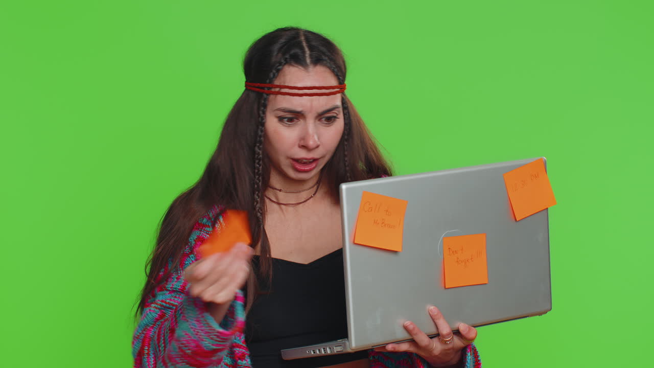 mujer independiente agotada con notas adhesivas pegadas usa portátil confundida por la gran carga de trabajo de rutina