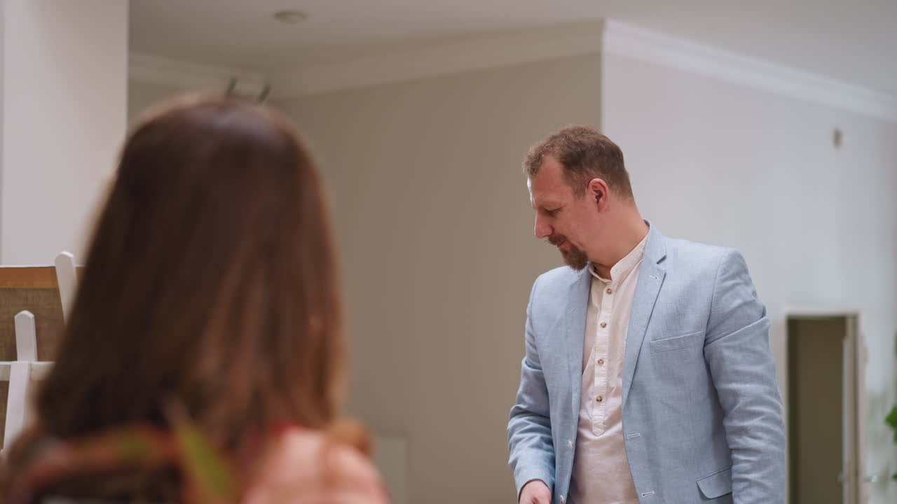 el artista piensa mirando la cara de la mujer modelo en el taller. el pintor positivo busca una posición interesante para el retrato en el estudio de arte. el hombre creativo en el trabajo