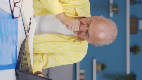 Vertical-video-of-Home-office-worker-old-man-is-sick-and-coughing.