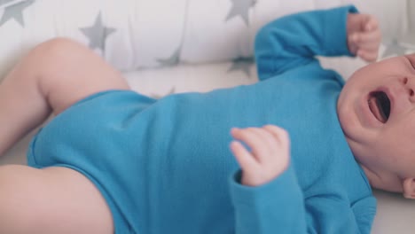 niño recién nacido molesto llora piernas molestas en el capullo dormido