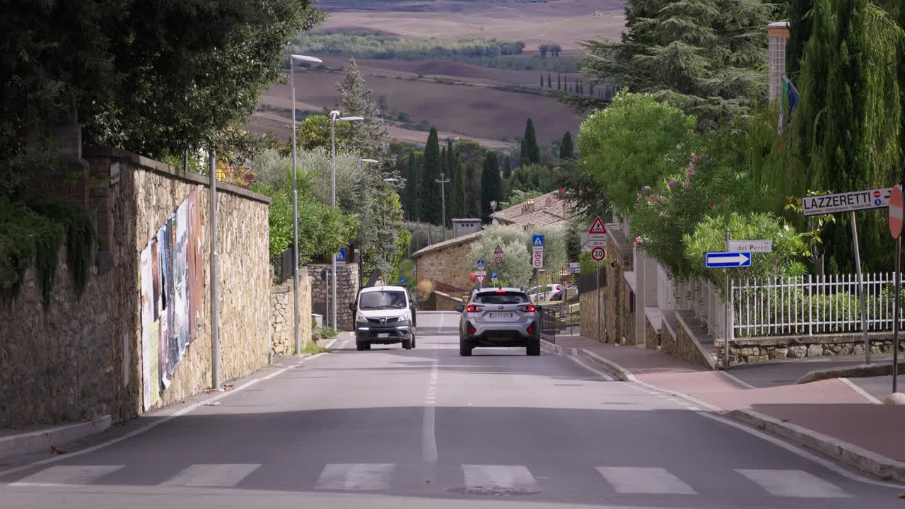 Cars driving along roads with scenic views in Tuscany Region