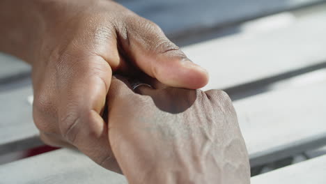 close-up of homosexual men touching each other hands with care