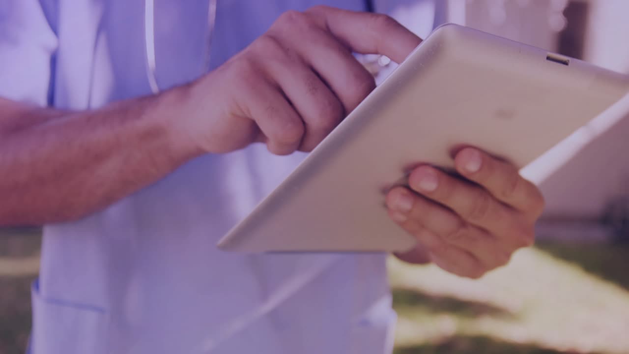 Mid adult man tapping tablet bar, animating holographic waveform graphs for patient monitoring