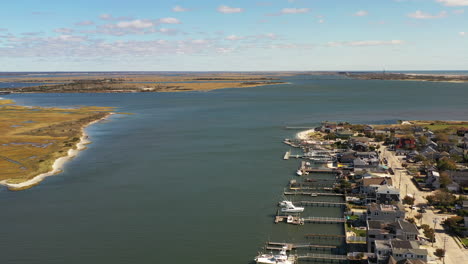 drone dolly shot forward over reynold's channel in point lookout, ny showing the back of the water front homes - the horizon in the distance near point lookout, ny