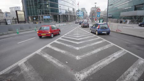 cars moving between symmetrical road markers in the city in the day