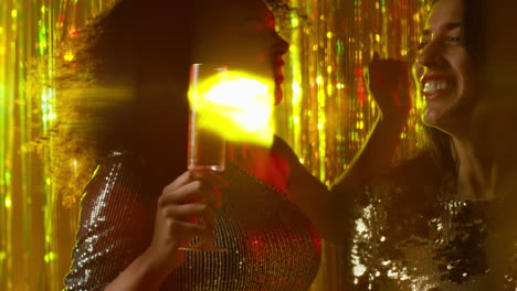 cerca de dos mujeres bailando en un bar de club nocturno o discoteca bebiendo alcohol con luces brillantes 21