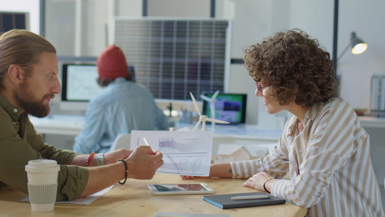 Colleagues Discussing Renewable Energy Project in Office