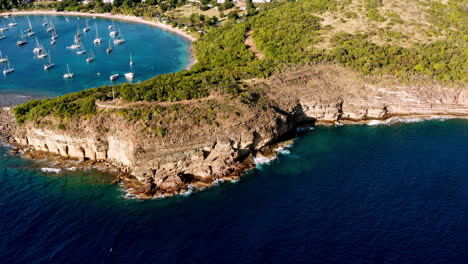 sunny aerial shot of english harbor in antigua, caribbean with views of yachts, sailboats, marina, bay and cliffs